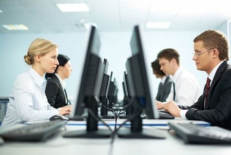 Employees working at computers, heading an article on Dubai salary levels