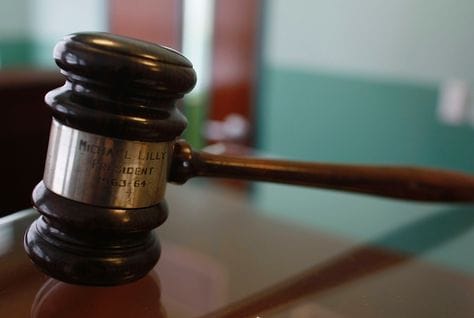 Gavel and legal documents, heading an article on labour law deportations in Oman