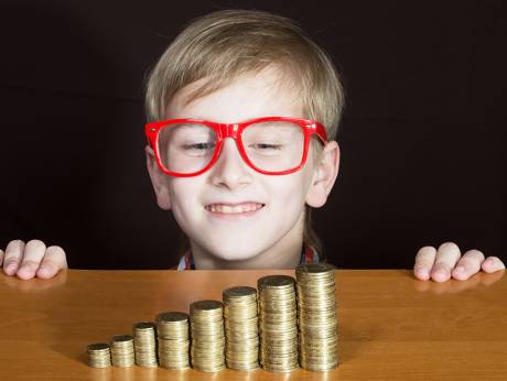 Child with pocket money, heading an article on teaching kids about money in the UAE